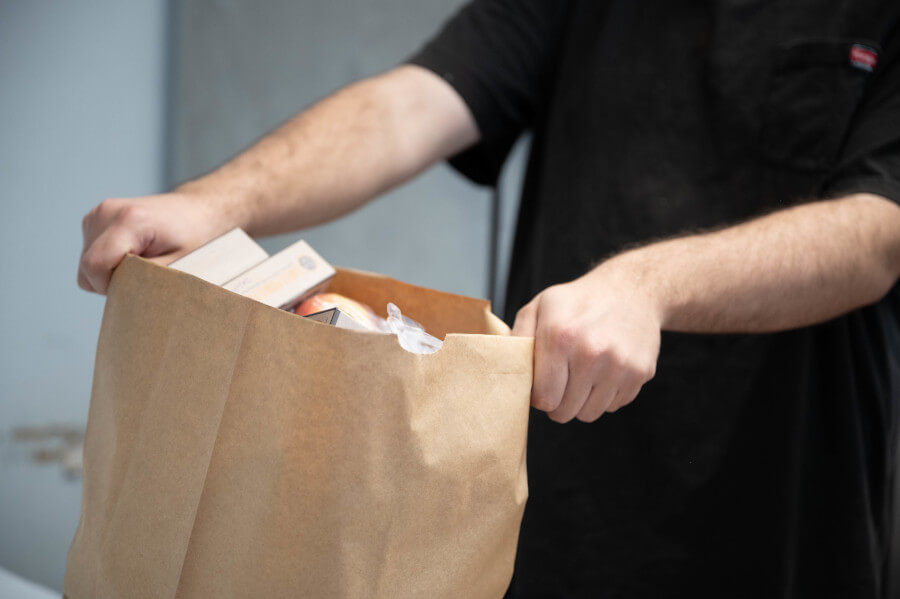 Looking into paper bag full of food for non-clients
